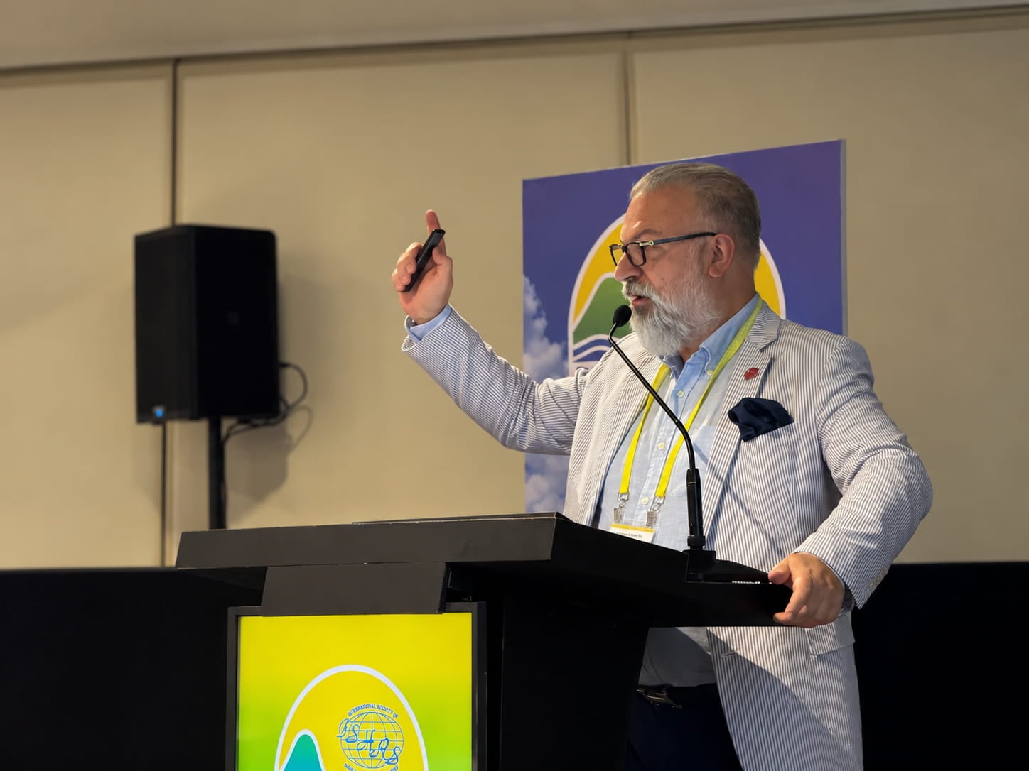 Dr. Anastasios Vekris delivering his scientific presentation at ISHRS Rio 2026.