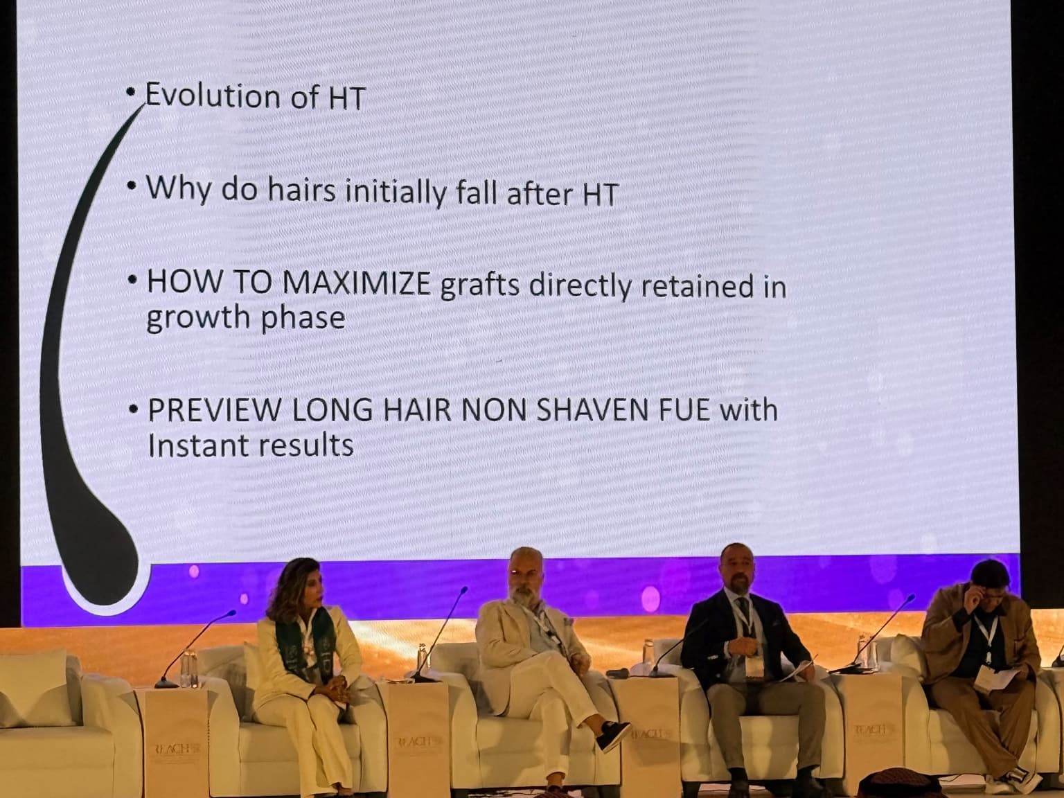 Four specialists participating in a REACH 2026 conference panel discussing hair transplantation and FUE techniques.