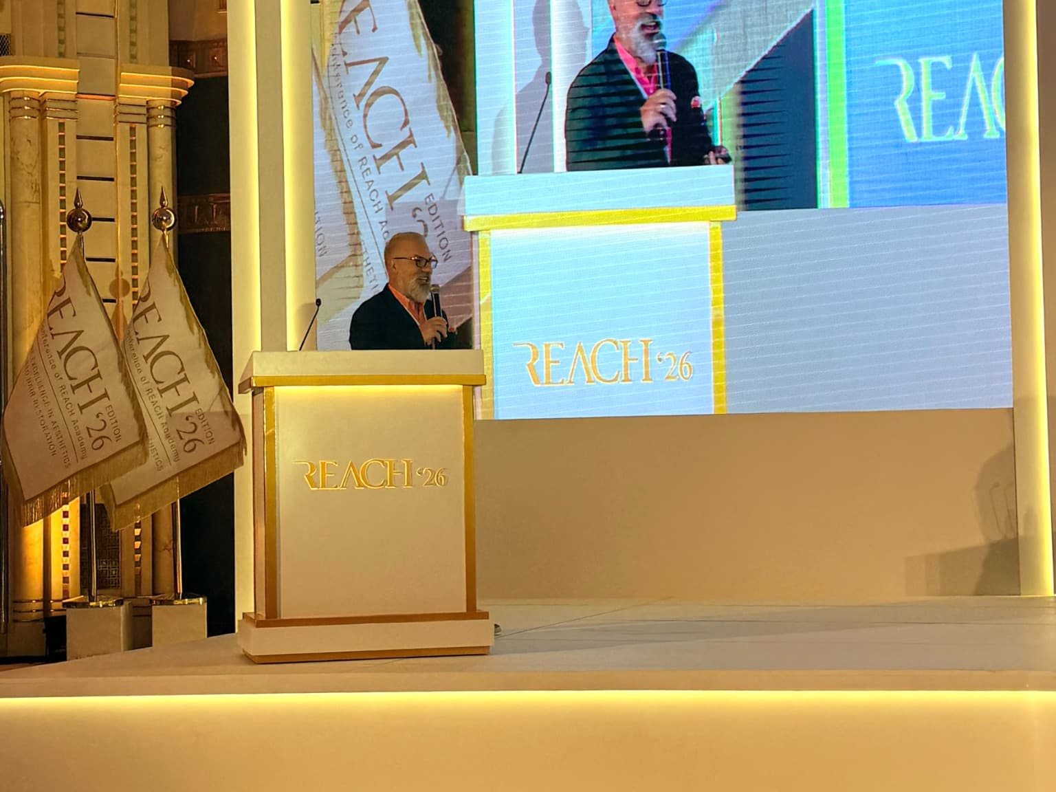 Medical speaker delivering a presentation at the REACH Conference 2026 in Jeddah, Saudi Arabia.